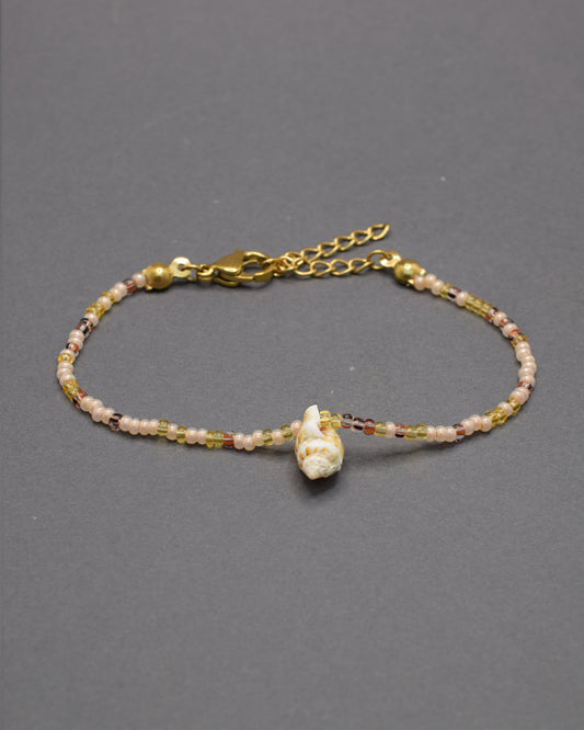 Pulseira Búzio de missangas em mix dourado, combinando brilho suave e detalhes naturais para um look elegante e leve, perfeito para o verão.
