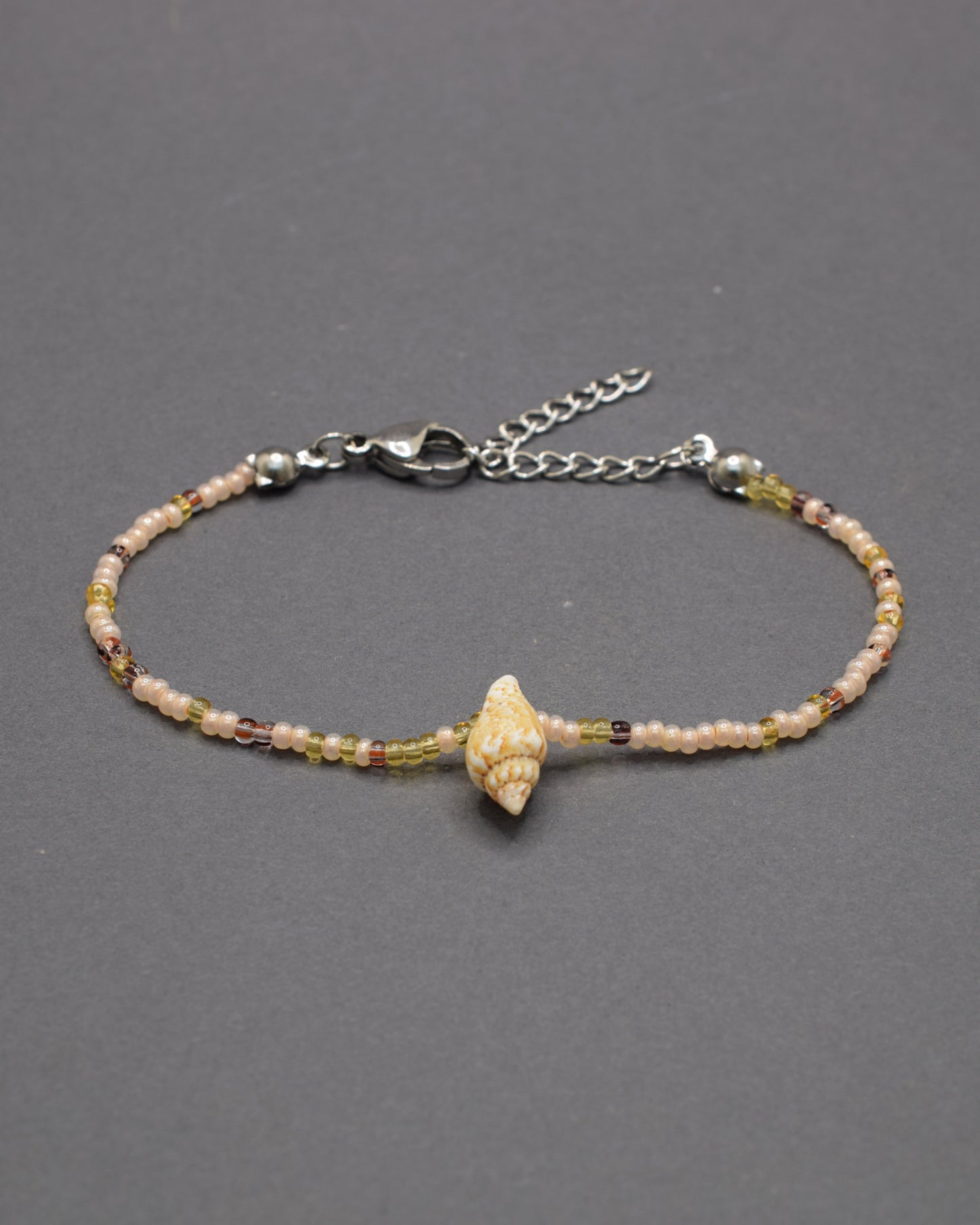 Pulseira Búzio de missangas em mix dourado, combinando brilho suave e detalhes naturais para um look elegante e leve, perfeito para o verão.