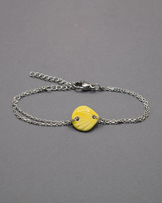 Pulseira com pendente de cerâmica em forma de concha amarela, leve e luminosa, perfeita para dar um toque solar e delicado ao teu estilo.