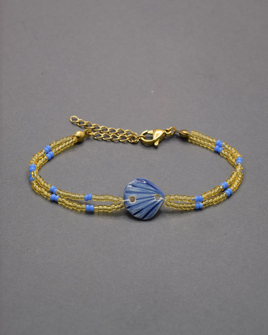 Pulseira com pendente de cerâmica em forma de concha azul escuro, elegante e sofisticada, ideal para um toque marítimo e refinado no seu look.