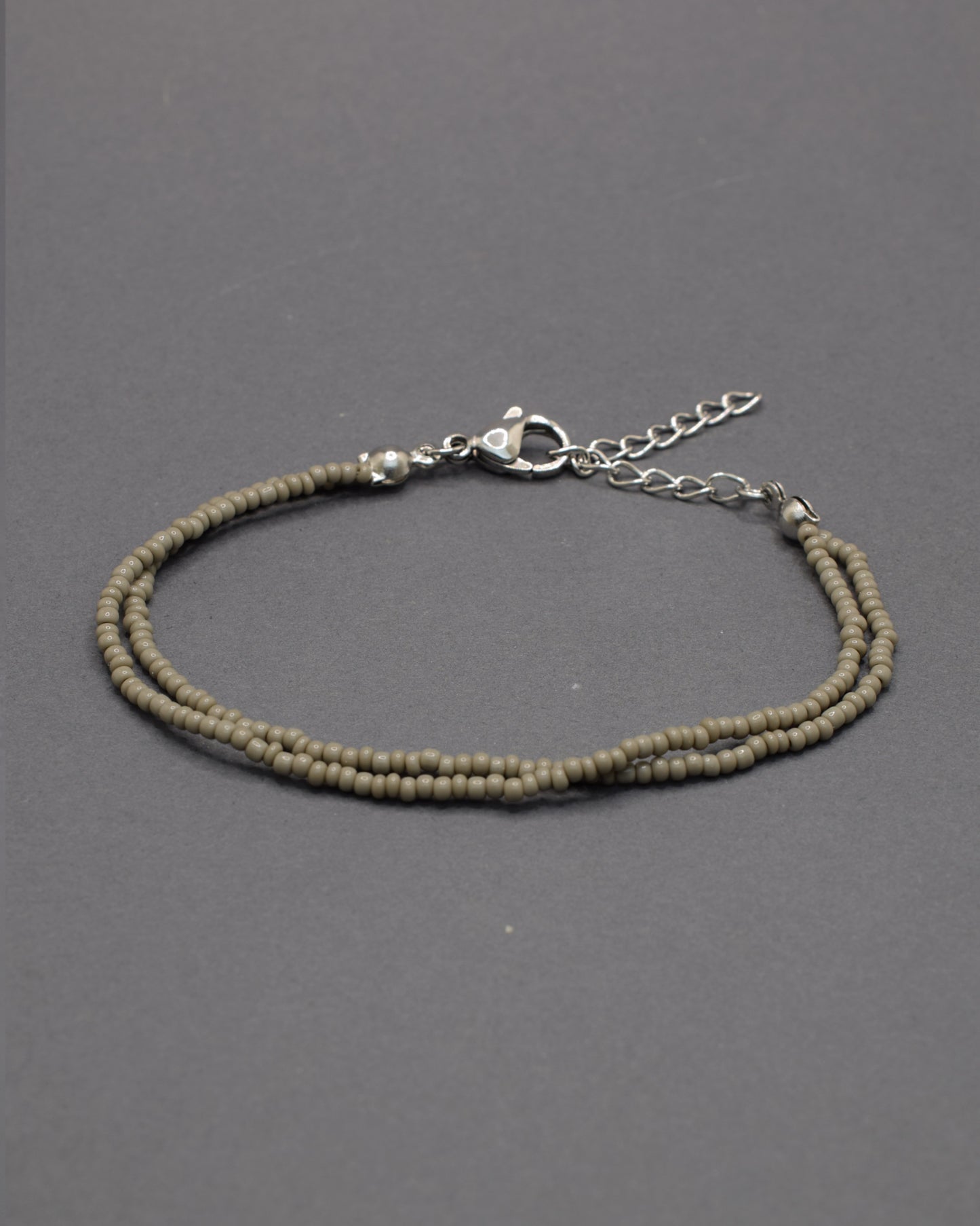 Pulseira dupla com missangas cinzentas. Design artesanal e elegante para um toque sofisticado no seu look.