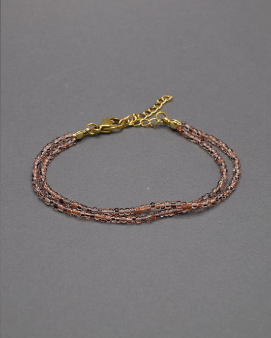 Pulseira Dupla de Missangas Listradas Castanhas, com design elegante e moderno. Perfeita para adicionar sofisticação ao seu estilo.