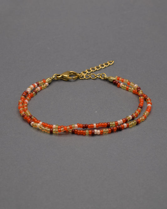 Pulseira dupla de missangas em vidro, mix vermelho-alaranjado com dourado, bordô e salmão. Efeito vibrante que irradia energia e sofisticação.