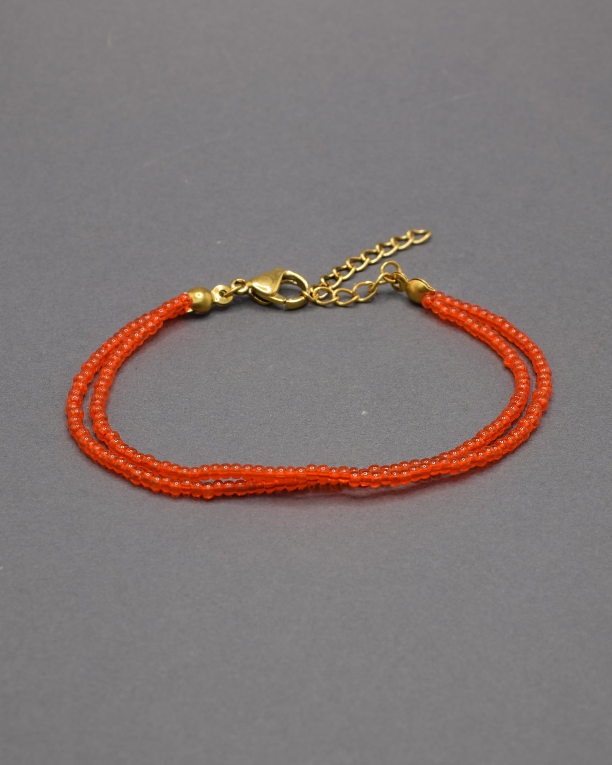 Pulseira dupla de missangas vermelhas-alaranjadas semitransparentes. Design artesanal e vibrante, perfeita para adicionar um toque de cor e elegância ao seu look.