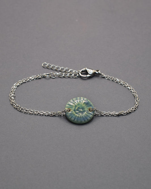 Pulseira delicada com pendente flor do mar em cerâmica verde musgo, inspirada na natureza e perfeita para um toque orgânico e sofisticado ao seu look.