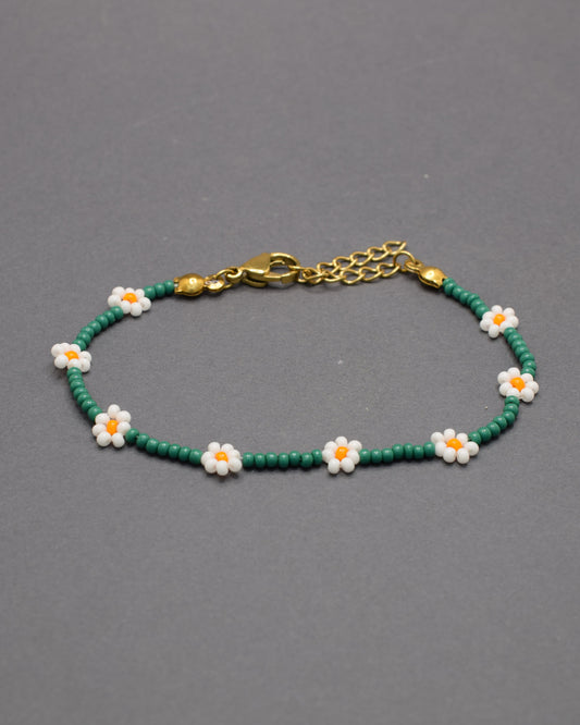 Pulseira de flores brancas com missangas verdes, elegante e natural, ideal para um look fresco e sofisticado com inspiração na natureza.