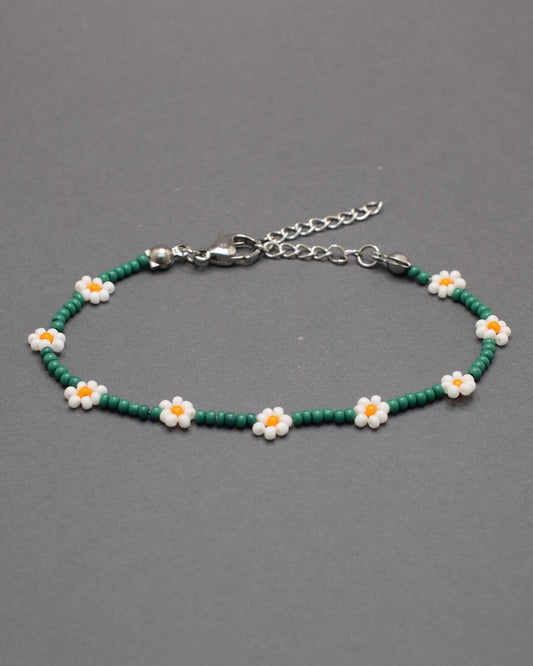 Pulseira de flores brancas com missangas verdes, elegante e natural, ideal para um look fresco e sofisticado com inspiração na natureza.