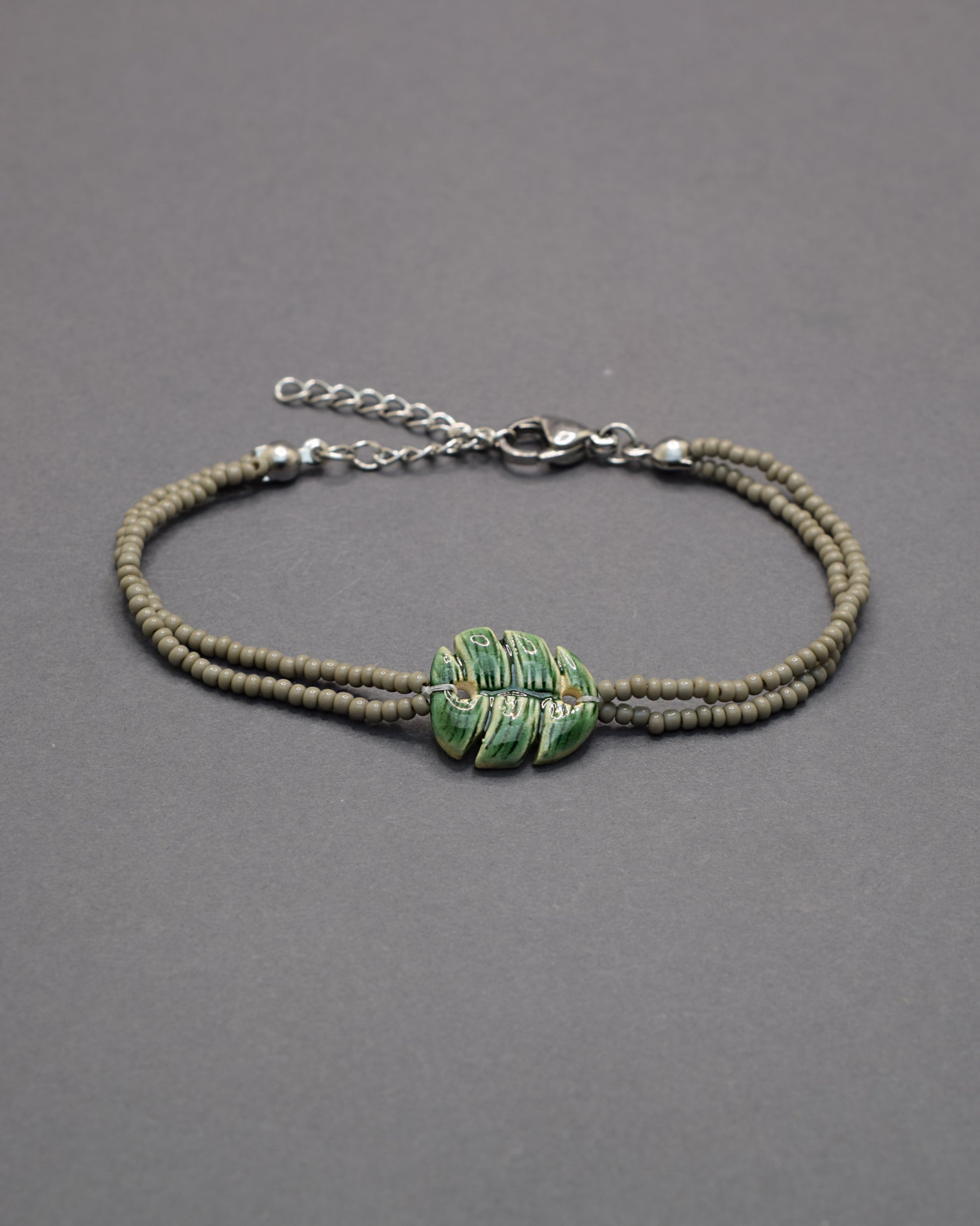 Pulseira delicada com pendente de folha verde em cerâmica, inspirada na natureza, leve e elegante para um toque fresco e sofisticado no seu dia a dia.