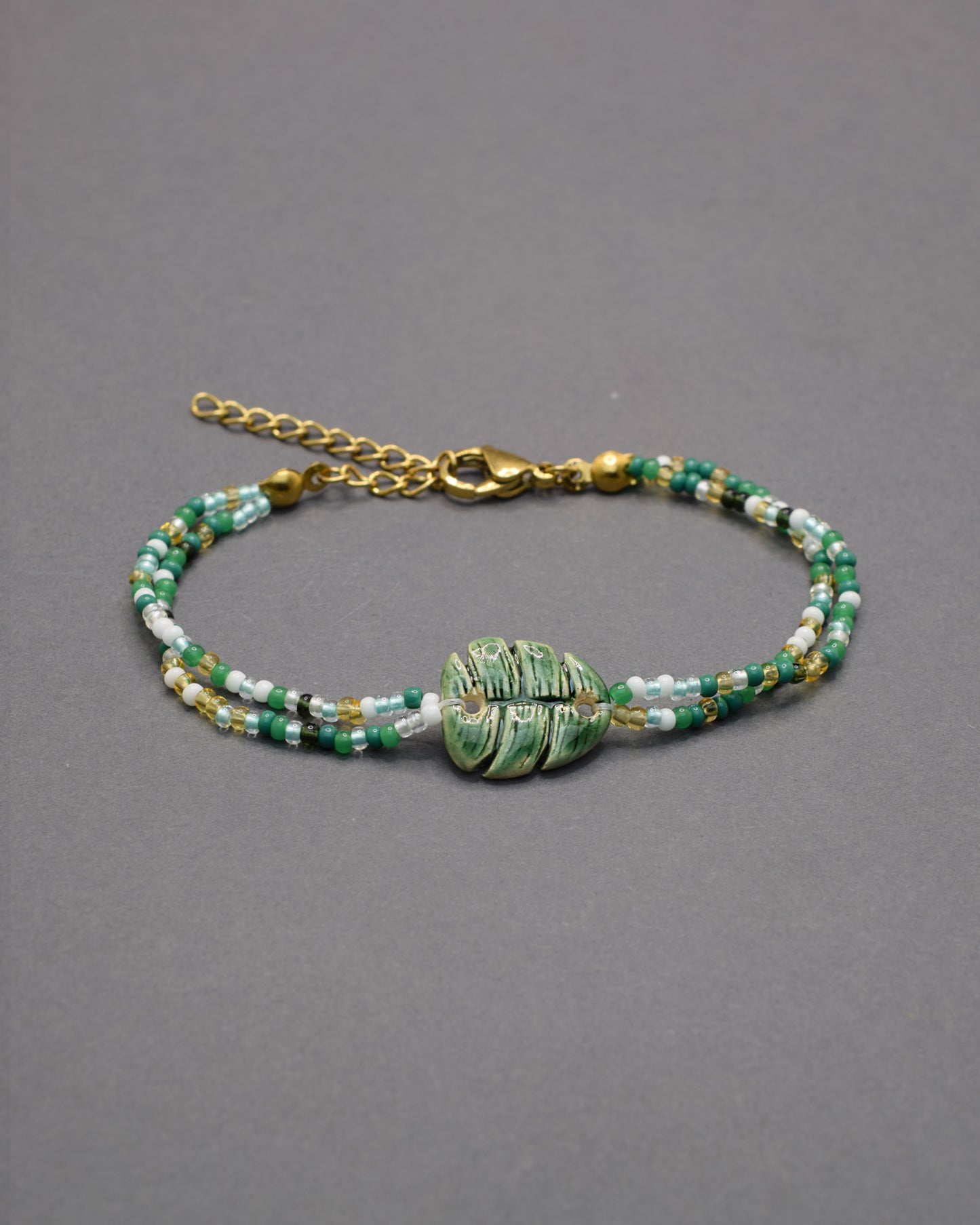 Pulseira delicada com pendente de folha verde em cerâmica, inspirada na natureza, leve e elegante para um toque fresco e sofisticado no seu dia a dia.