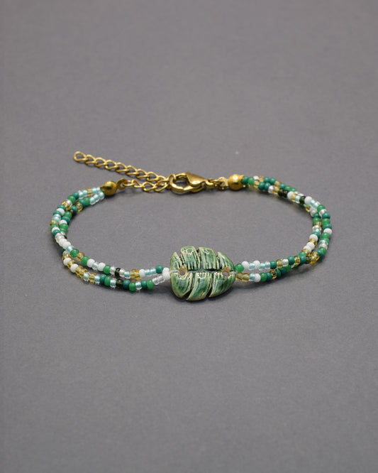 Pulseira delicada com pendente de folha verde em cerâmica, inspirada na natureza, leve e elegante para um toque fresco e sofisticado no seu dia a dia.