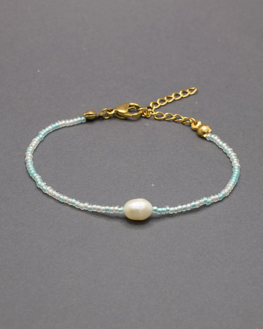 Delicada pulseira de missangas mix turquesa semitransparente com pérola, perfeita para um toque de elegância.