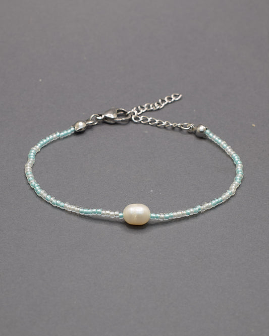 Delicada pulseira de missangas mix turquesa semitransparente com pérola, perfeita para um toque de elegância.